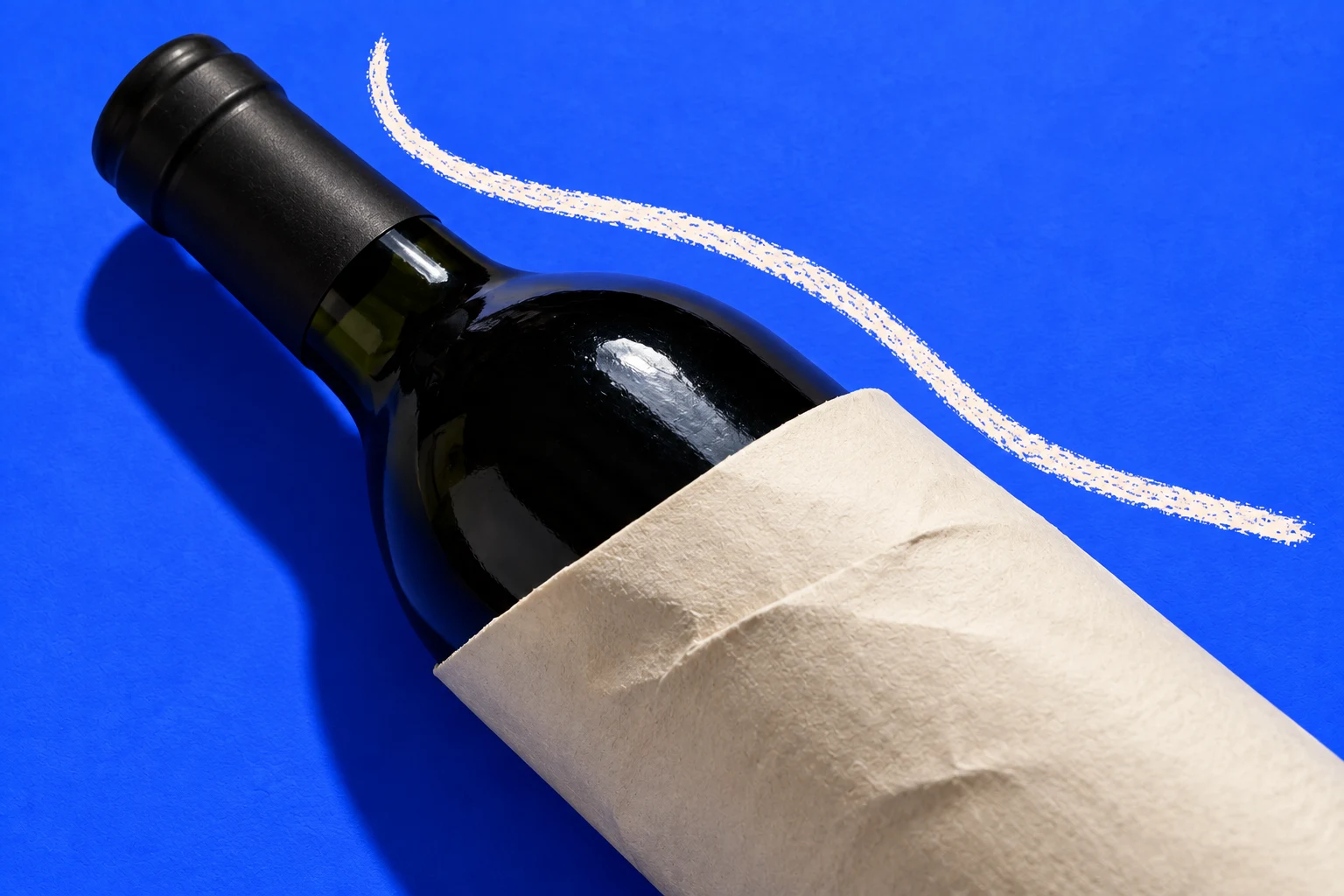 Bouteille enveloppée dans un papier kraft sur fond bleu